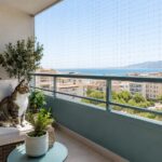 Γάτα σε ασφαλές μπαλκόνι ενοικιαζόμενου σπιτιού με διακριτικό προστατευτικό δίχτυ