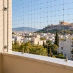 Προστατευμένο μπαλκόνι με διακριτικό δίχτυ και περιστέρι έξω από την προστατευμένη περιοχή